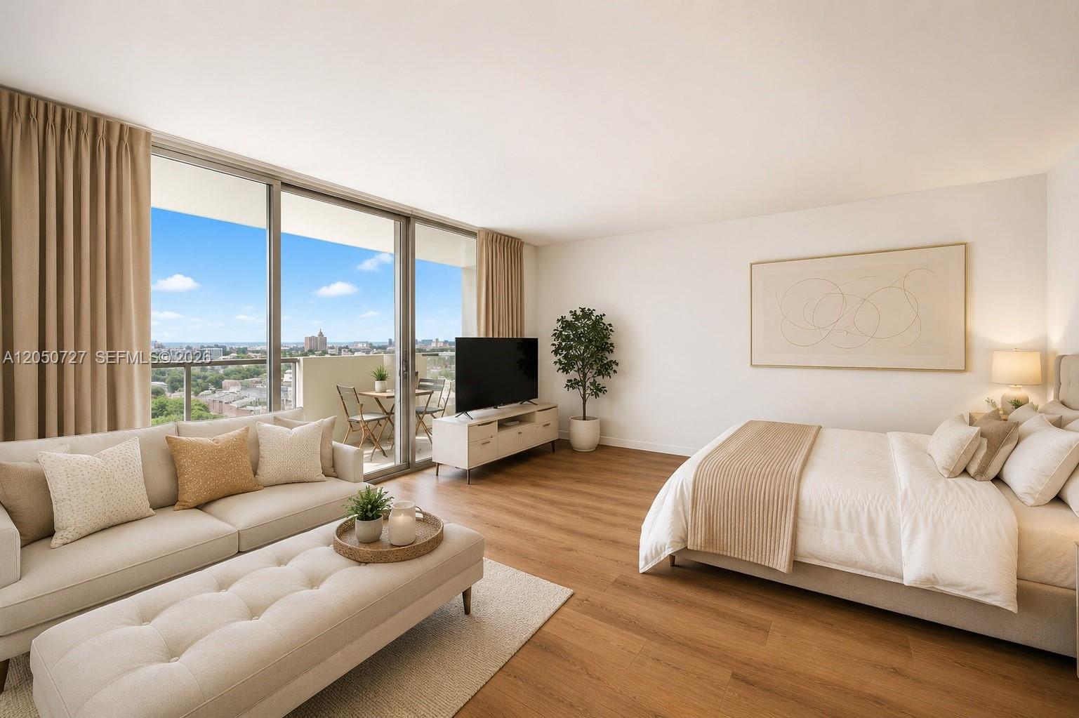A studio apartment features a bed, sofa, television, and a balcony with a city view — 1200 West Ave, Miami Beach FL 33139, MIAMI BEACH, FL
