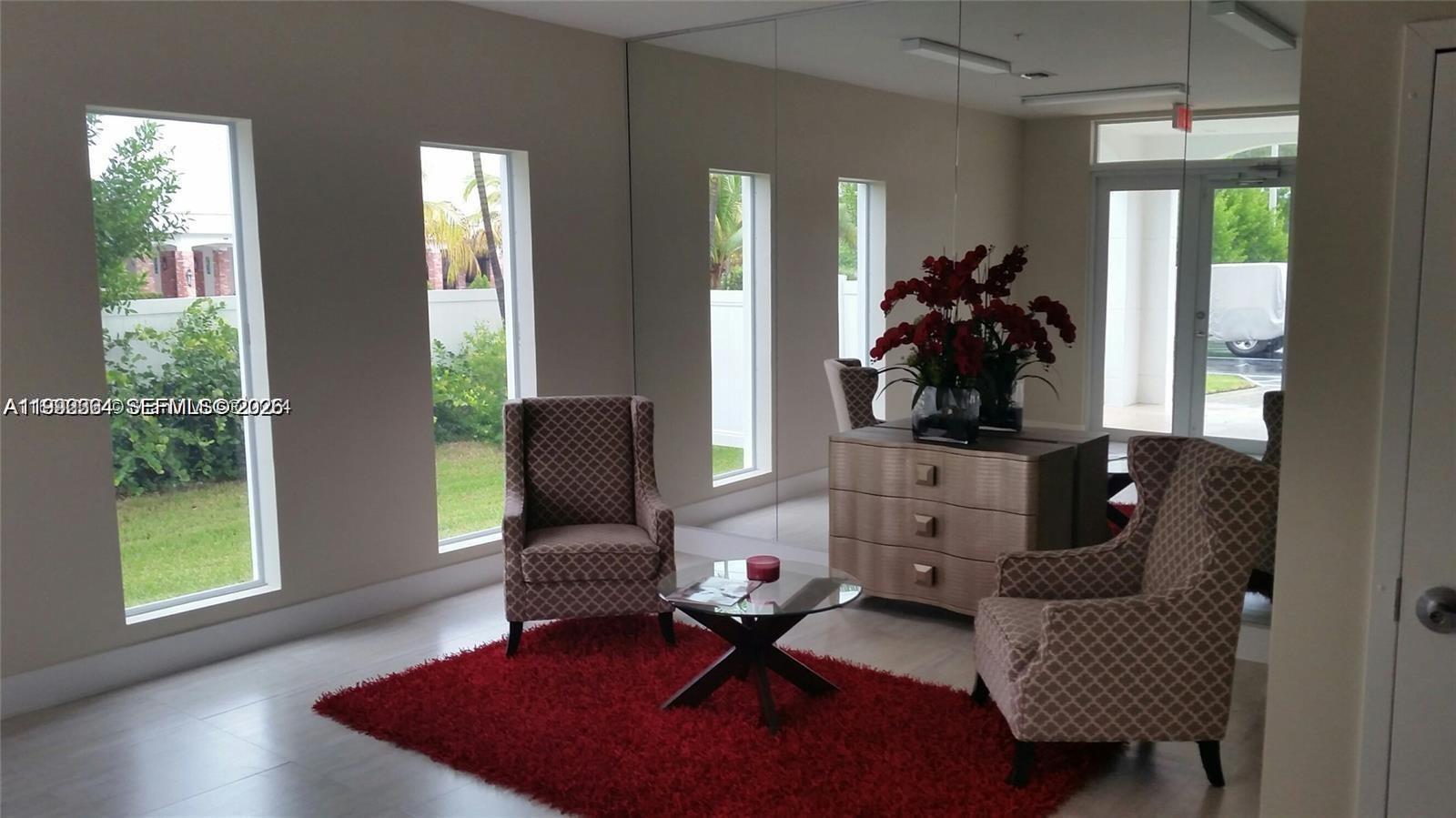 A room features two patterned armchairs, a glass coffee table, a red rug, and mirrors — 555 E Dania Beach Blvd # 5, Dania Beach FL 33004, DANIA BEACH, FL