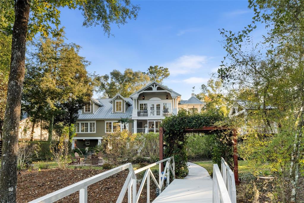 A two-story house with a metal roof and a wooden bridge leading to the yard — 174 NE 972ND STREET, BRANFORD, FL
