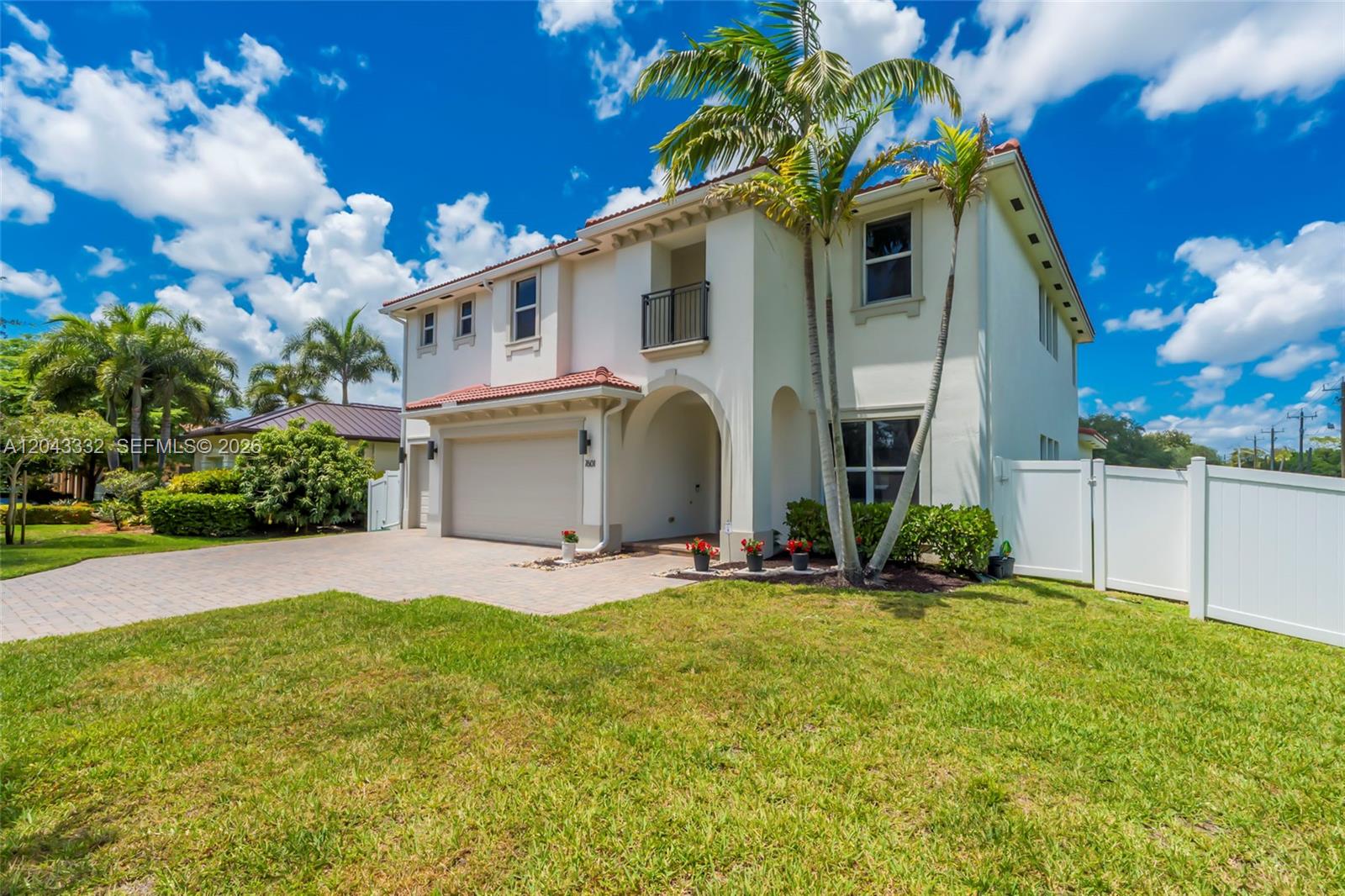 A two-story stucco house with a tile roof, a two-car garage, and palm trees — 7601 Cavalia Dr, Davie FL 33328, DAVIE, FL