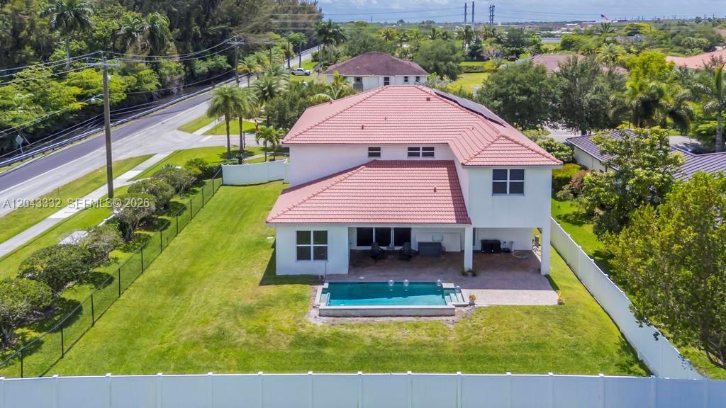 An aerial view of a two-story house with a red tile roof and backyard pool — 7601 Cavalia Dr, Davie FL 33328, DAVIE, FL