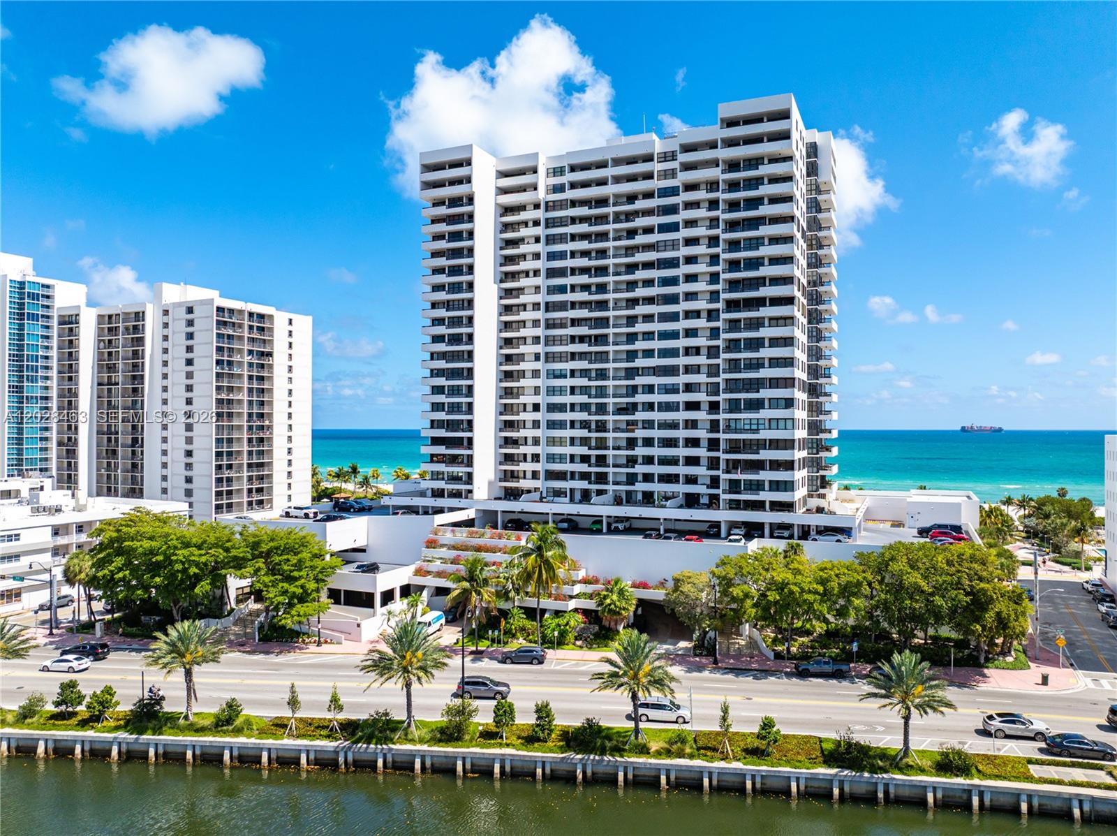 An exterior view of a tall residential high-rise building situated along a coastal road — 2555 Collins Ave # 403, Miami Beach FL 33140, MIAMI BEACH, FL