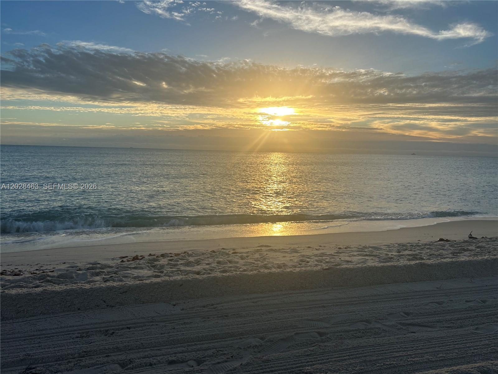 A view of the ocean at sunrise from a sandy beach — 2555 Collins Ave # 403, Miami Beach FL 33140, MIAMI BEACH, FL