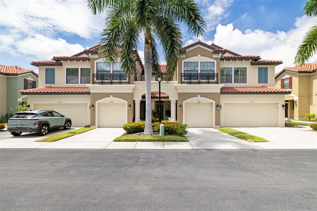 An aerial view shows a residential complex with red-tiled roofs and a circled building — 4968 OARSMAN COURT, SARASOTA, FL