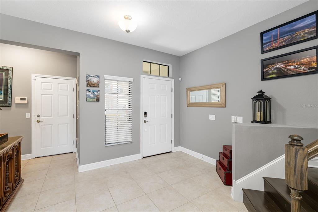 A two-story residential building features four garage doors, a palm tree, and a tiled roof — 4968 OARSMAN COURT, SARASOTA, FL