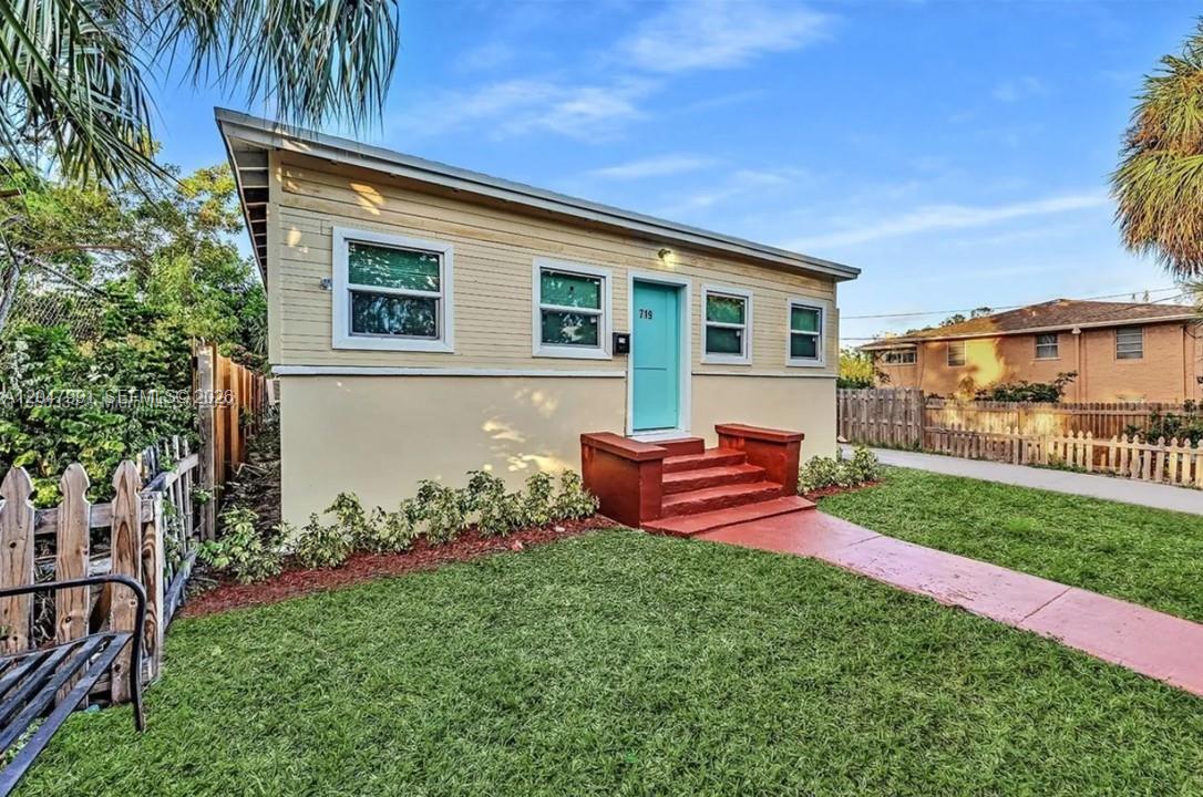 A backyard patio features a sofa, a small table, and chairs on a paved area — 719 9th St, West Palm Beach FL 33401, WEST PALM BEACH, FL