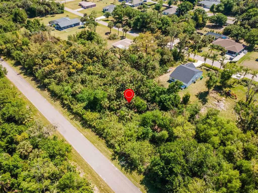 An aerial view shows a vacant, wooded residential lot marked with a red circle — 22471 MOROCCO AVENUE, PORT CHARLOTTE, FL