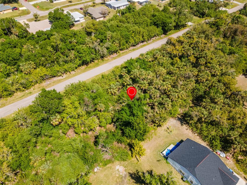 An aerial view shows a wooded lot with a red location marker near a road — 22471 MOROCCO AVENUE, PORT CHARLOTTE, FL