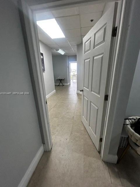 A doorway opens into a hallway with light-colored tile flooring and a white door — 900 W 49th St Suite 420, Hialeah FL 33012, HIALEAH, FL