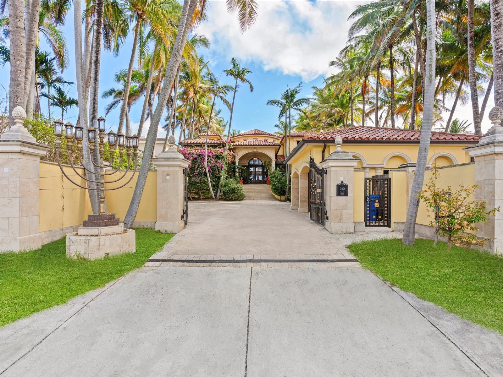 A gated driveway leads to a Mediterranean-style house with a large menorah sculpture in front — 555 Ocean Boulevard, Golden Beach FL 33160, GOLDEN BEACH, FL
