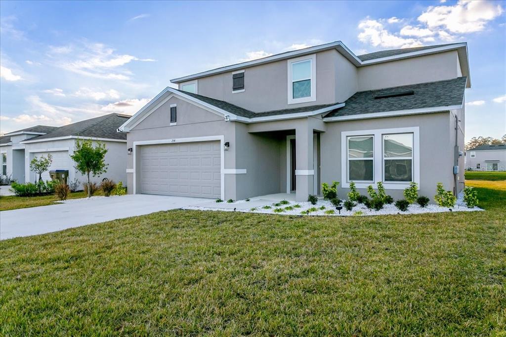 A two-story suburban house with a gray exterior, a two-car garage, and a front lawn — 254 AMBER WAY, KISSIMMEE, FL