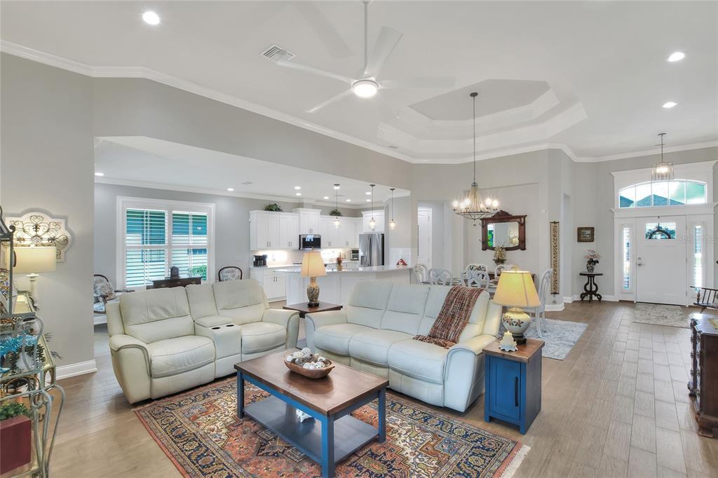 A living room with light-colored sofas, a wooden coffee table, and an open-concept kitchen — 7770 LAKE JAMES BOULEVARD, LAKELAND, FL