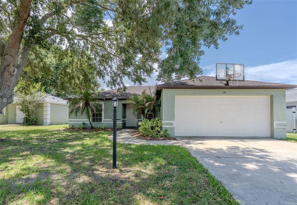 A single-story house with a green exterior, a two-car garage, and a basketball hoop — 145 EAGLE POINT BOULEVARD, AUBURNDALE, FL
