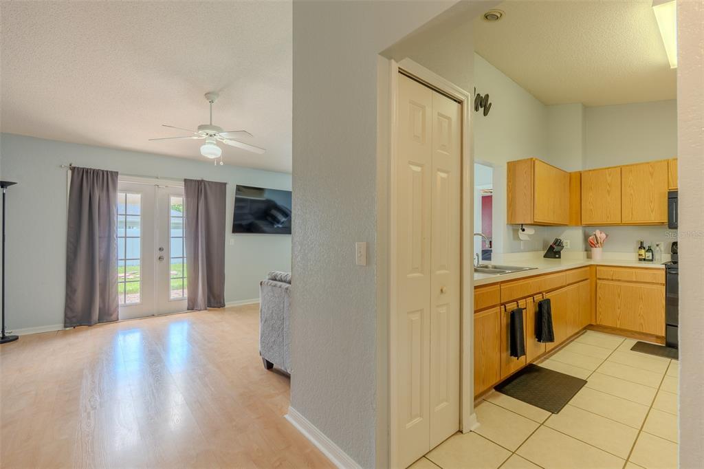 A view from a hallway looking into a living room and an adjacent kitchen — 145 EAGLE POINT BOULEVARD, AUBURNDALE, FL