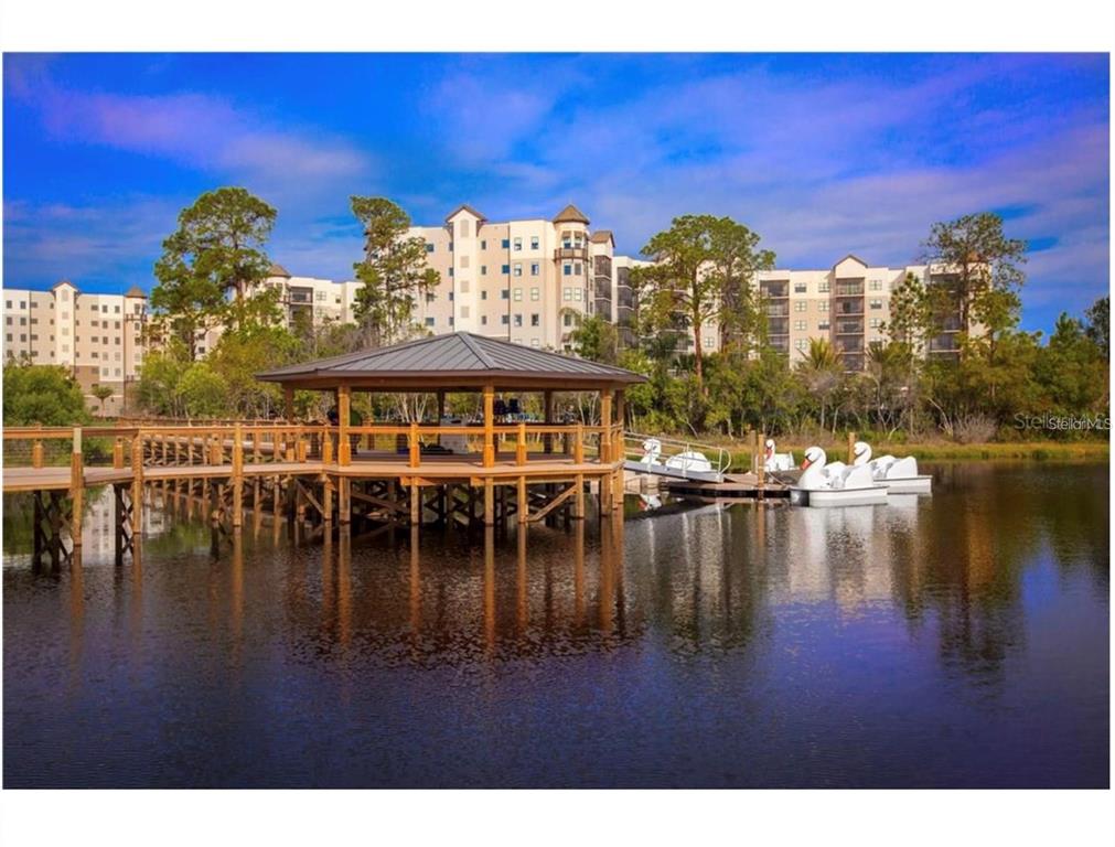 A wooden gazebo sits on a lake with swan-shaped pedal boats docked nearby — 14501 GROVE RESORT AVENUE UNIT 1343, WINTER GARDEN, FL