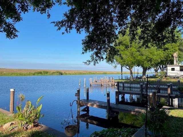 A wooden dock extends into a calm lake under a clear blue sky — 8680 Us Highway 441 SE # 35, Okeechobee FL 34974, OKEECHOBEE, FL