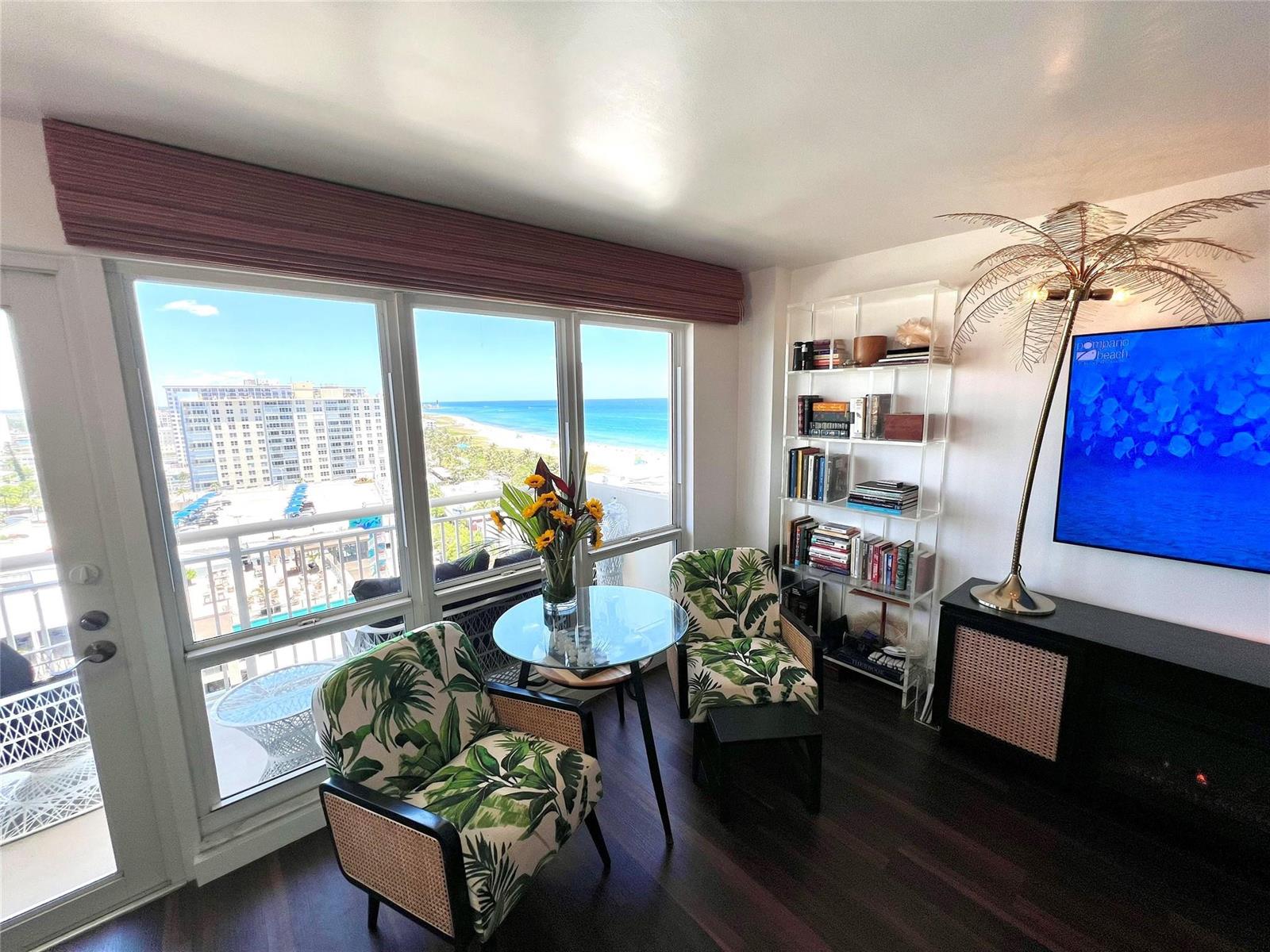 A living area features two palm-print chairs, a glass table, and a view of the ocean — 133 N Pompano Beach Boulevard # 1506, Pompano Beach FL 33062, POMPANO BEACH, FL