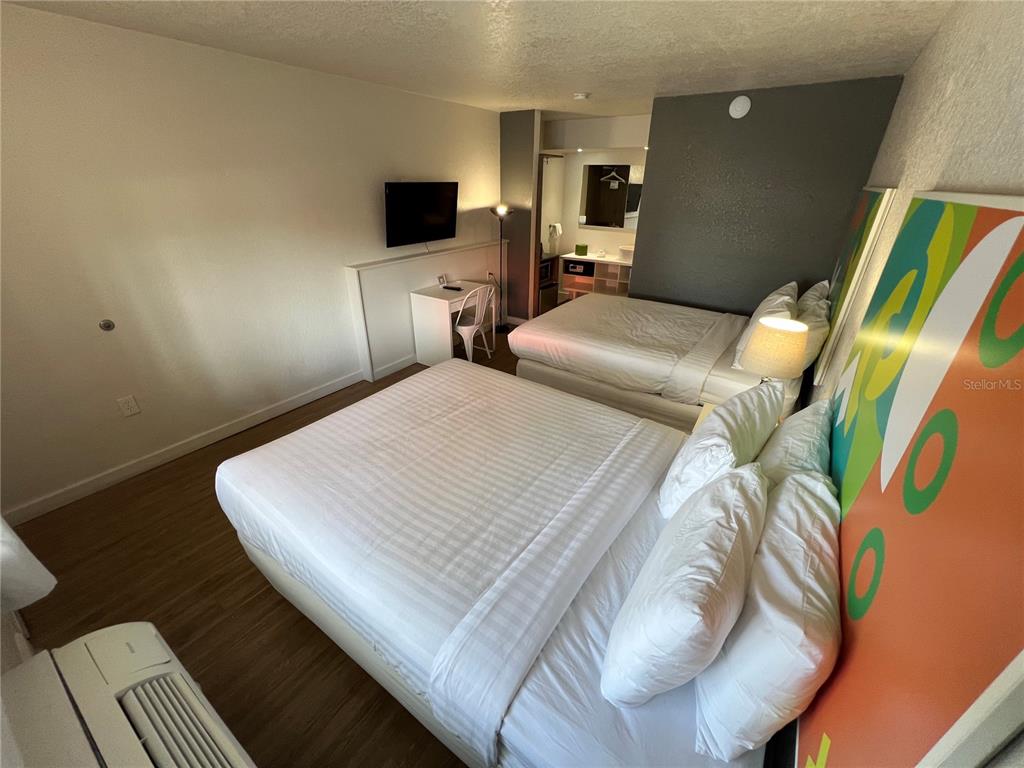 A hotel room features two beds, a desk, a television, and an attached vanity area — 5367 W IRLO BRONSON MEMORIAL HWY UNIT 1-103, KISSIMMEE, FL