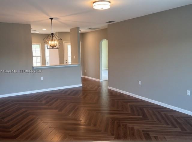 An open-concept living area features herringbone-patterned wood flooring and a kitchen island with pendant lighting — 3017 Driftwood Way # 0, Naples FL 34109, NAPLES, FL