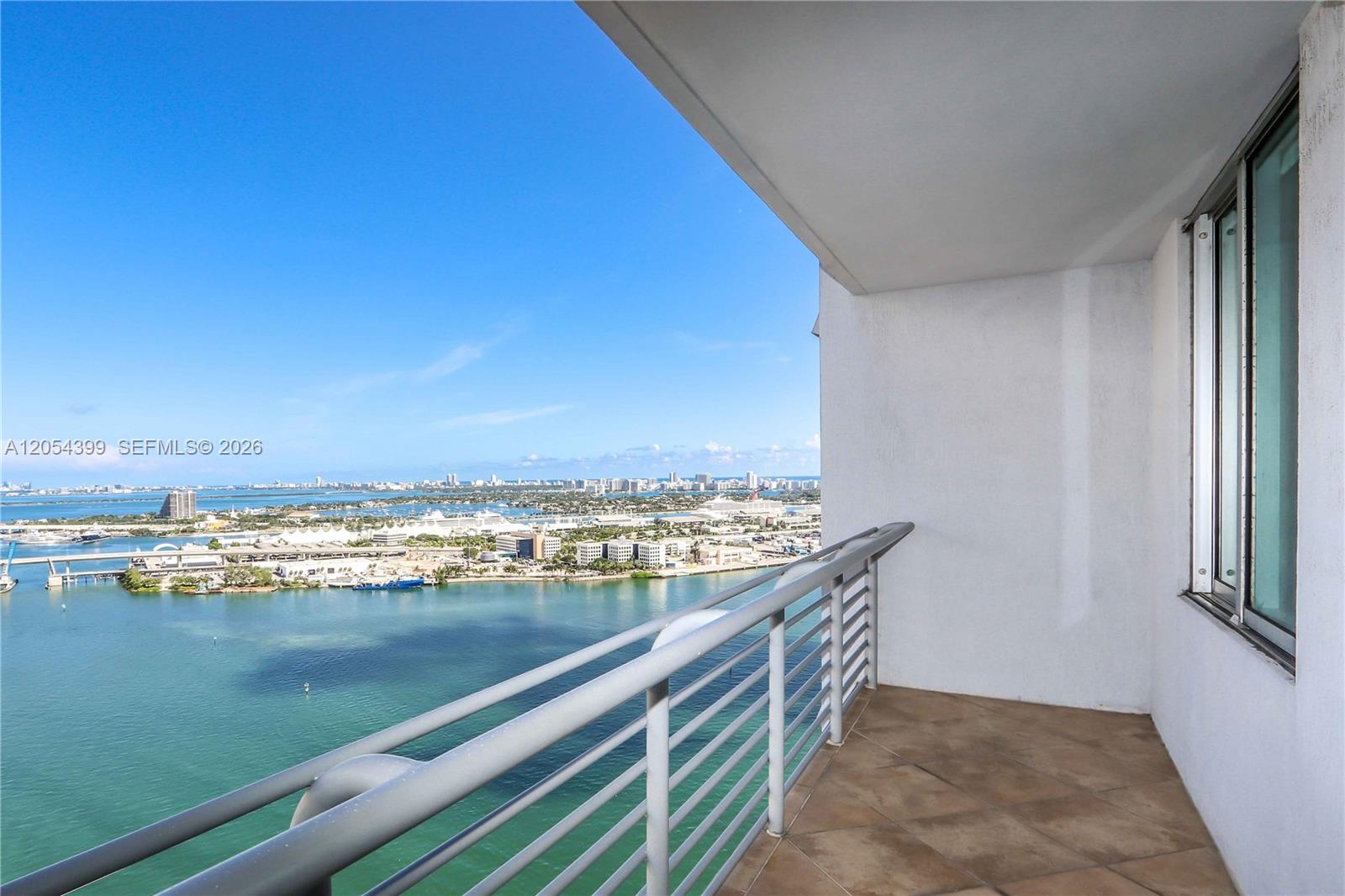 A balcony with a metal railing overlooks a bay and a city skyline — 335 S Biscayne Blvd # 3510, Miami FL 33131, MIAMI, FL