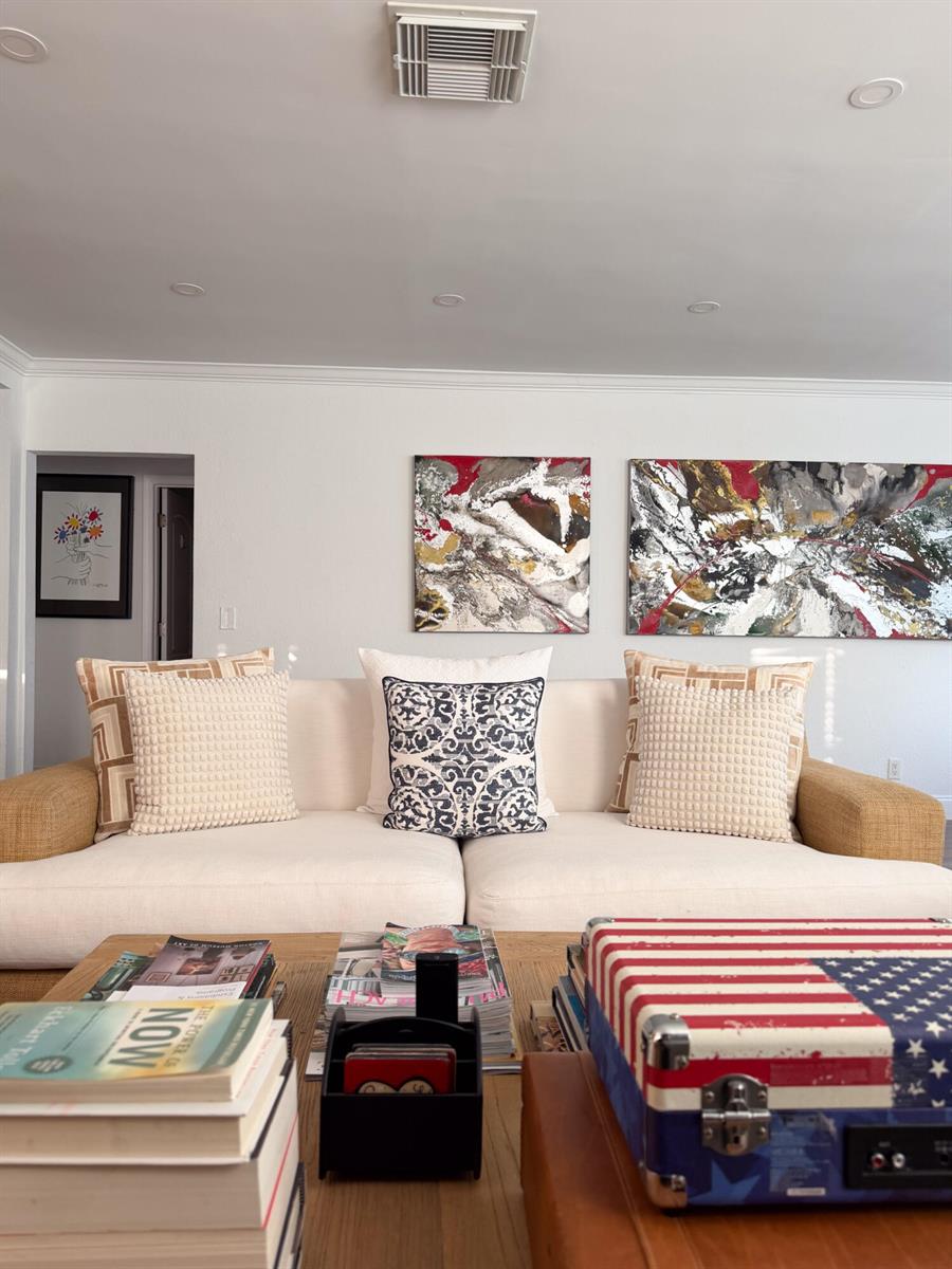 A living room features a beige sofa with patterned pillows, abstract wall art, and a coffee table — 521 Hampton Road, West Palm Beach FL 33405, WEST PALM BEACH, FL