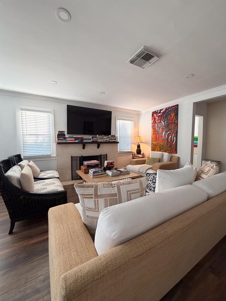 A living room features a fireplace with a television above, seating, and hardwood floors — 521 Hampton Road, West Palm Beach FL 33405, WEST PALM BEACH, FL