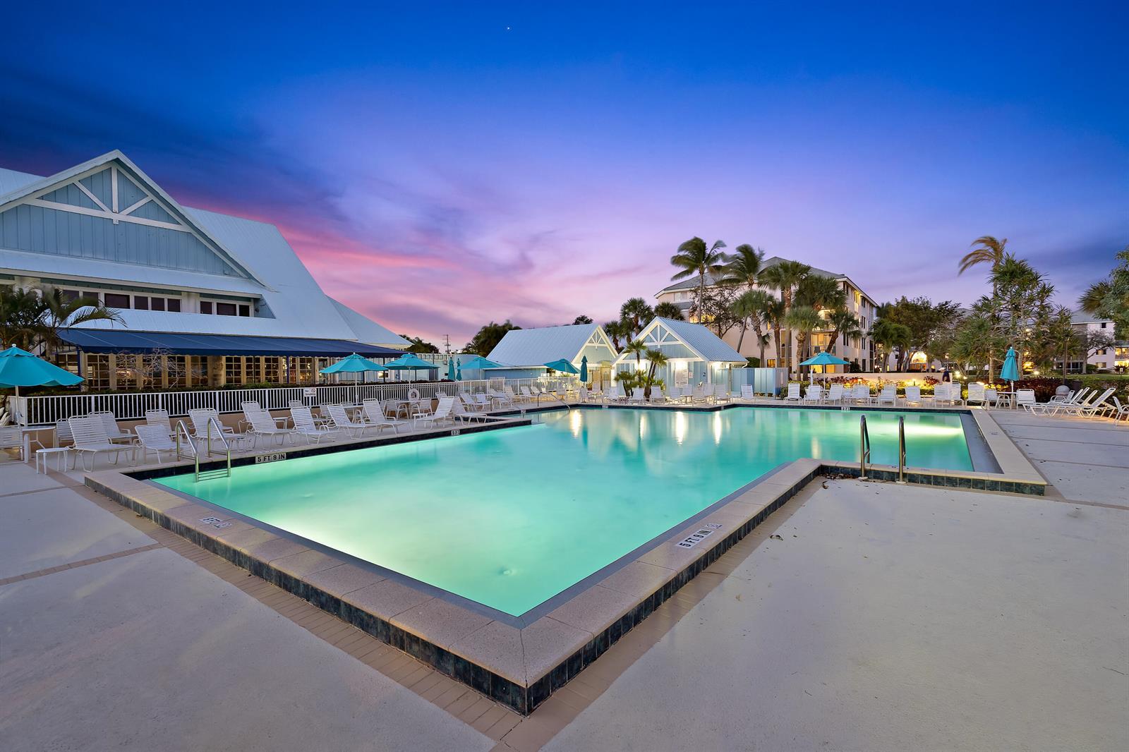 A large swimming pool sits in front of resort buildings under a colorful sunset sky — 353 S Us Highway 1 # A203, Jupiter FL 33477, JUPITER, FL