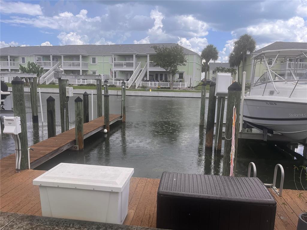 A wooden boat dock with storage bins sits on a canal in front of apartments — 0 BEACH DRIVE SE UNIT 151SS, ST PETERSBURG, FL