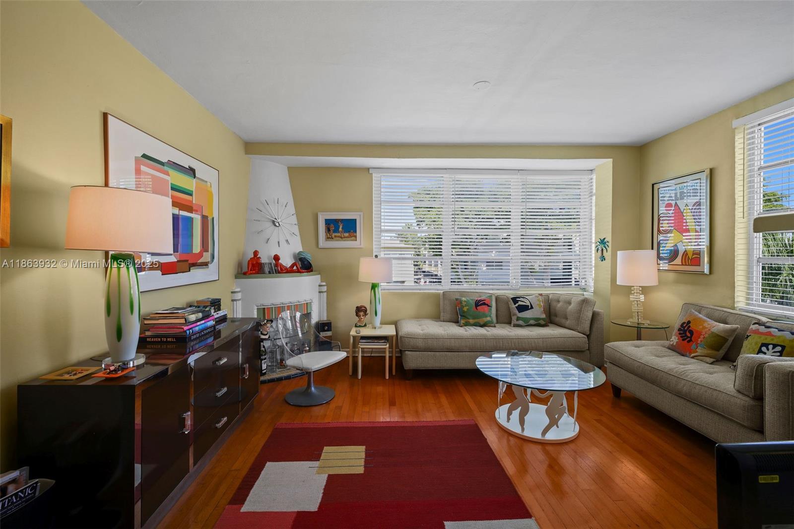 A living room features hardwood floors, a fireplace, two sofas, and large windows with blinds — 1525 Meridian Ave # 202, Miami Beach FL 33139, MIAMI BEACH, FL