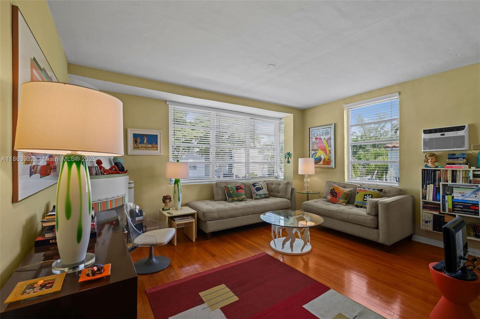 A living room features two beige sofas, a glass coffee table, and hardwood floors — 1525 Meridian Ave # 202, Miami Beach FL 33139, MIAMI BEACH, FL
