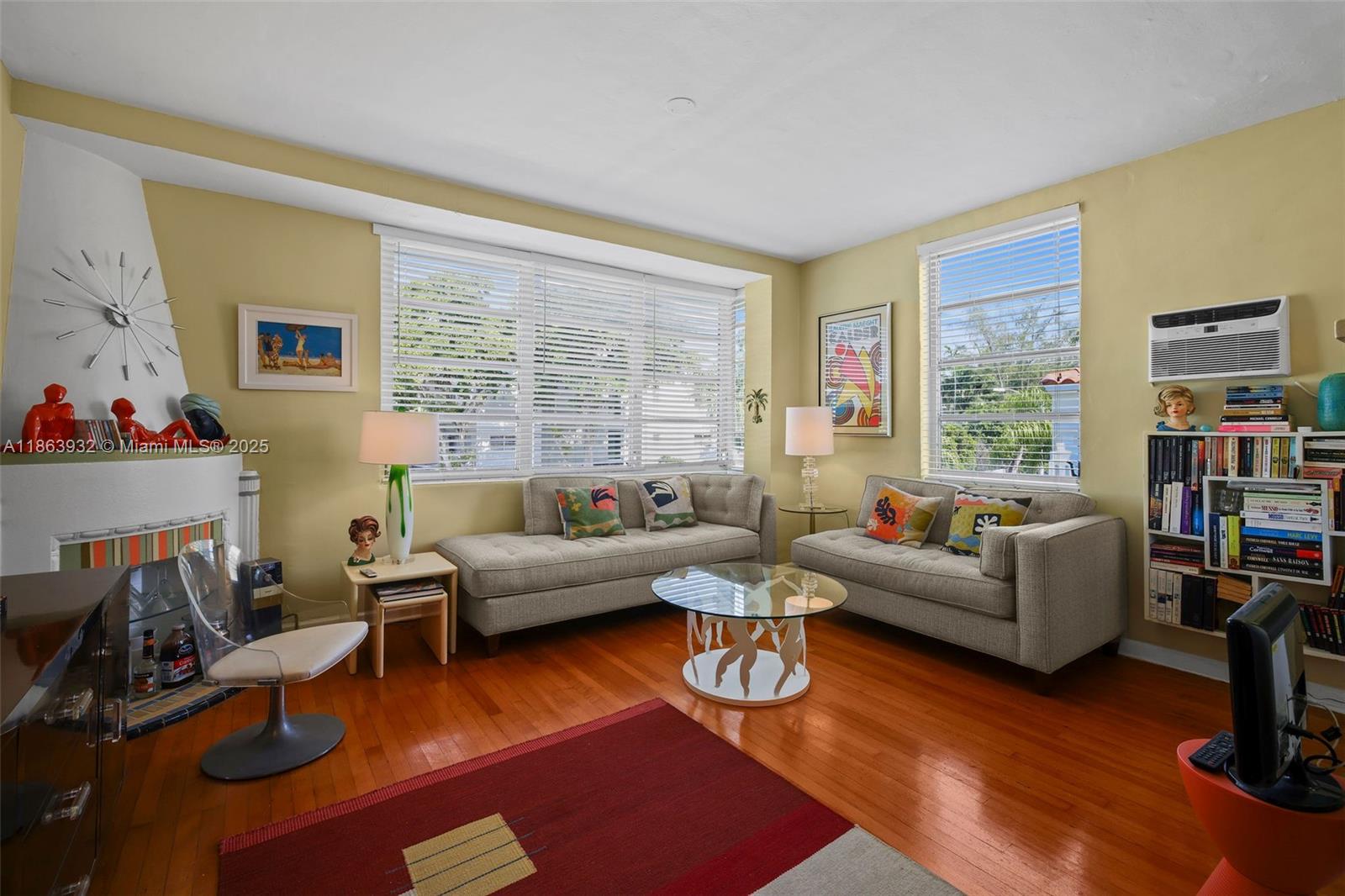 A living room features two gray sofas, a glass coffee table, and a fireplace — 1525 Meridian Ave # 202, Miami Beach FL 33139, MIAMI BEACH, FL