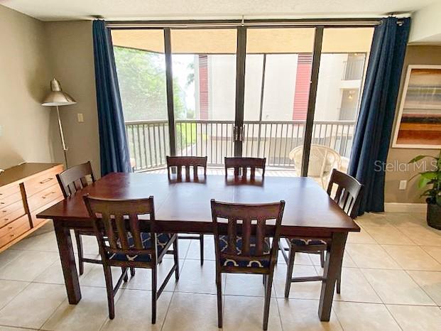 A dining room features a wooden table, six chairs, and large sliding glass balcony doors — 5611 GULF OF MEXICO DRIVE UNIT 5, LONGBOAT KEY, FL
