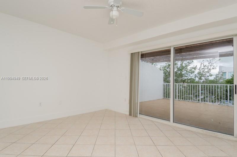 An empty room with white walls, tile flooring, a ceiling fan, and a sliding glass door — 2734 Bird Ave # 310, Miami FL 33133, MIAMI, FL