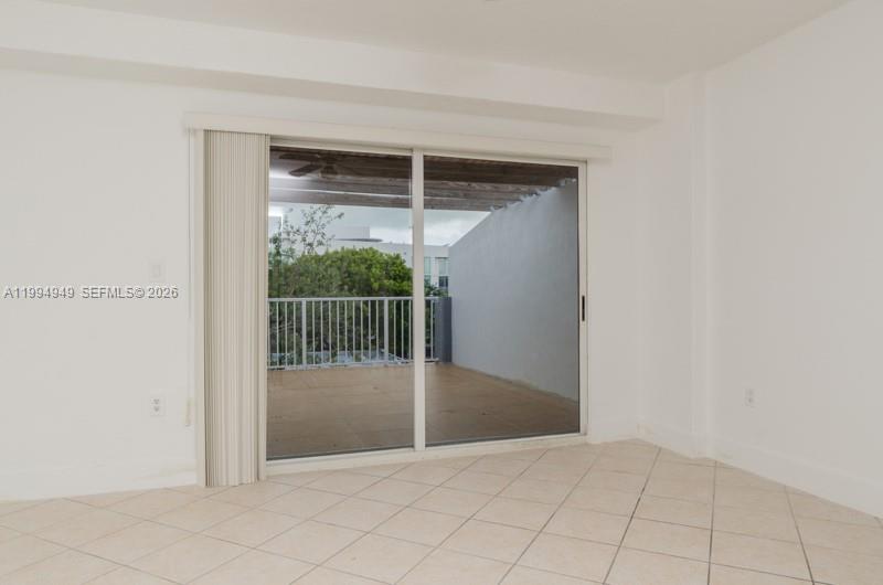 A room with white walls, tiled floors, and a sliding glass door leading to a balcony — 2734 Bird Ave # 310, Miami FL 33133, MIAMI, FL