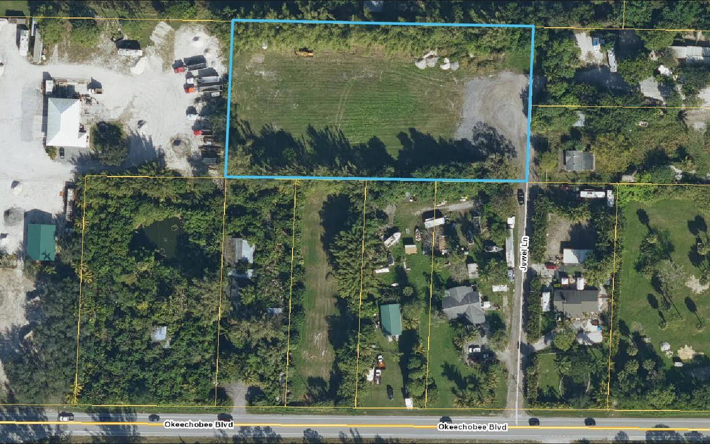 An aerial view shows a rectangular vacant lot outlined in blue near a paved road — 2105 Jewel Lane, FL 33470, FL