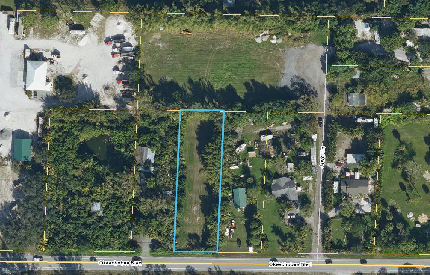 An aerial view shows a rectangular vacant lot bordered by trees along Okeechobee Boulevard — 2105 Jewel Lane, FL 33470, FL