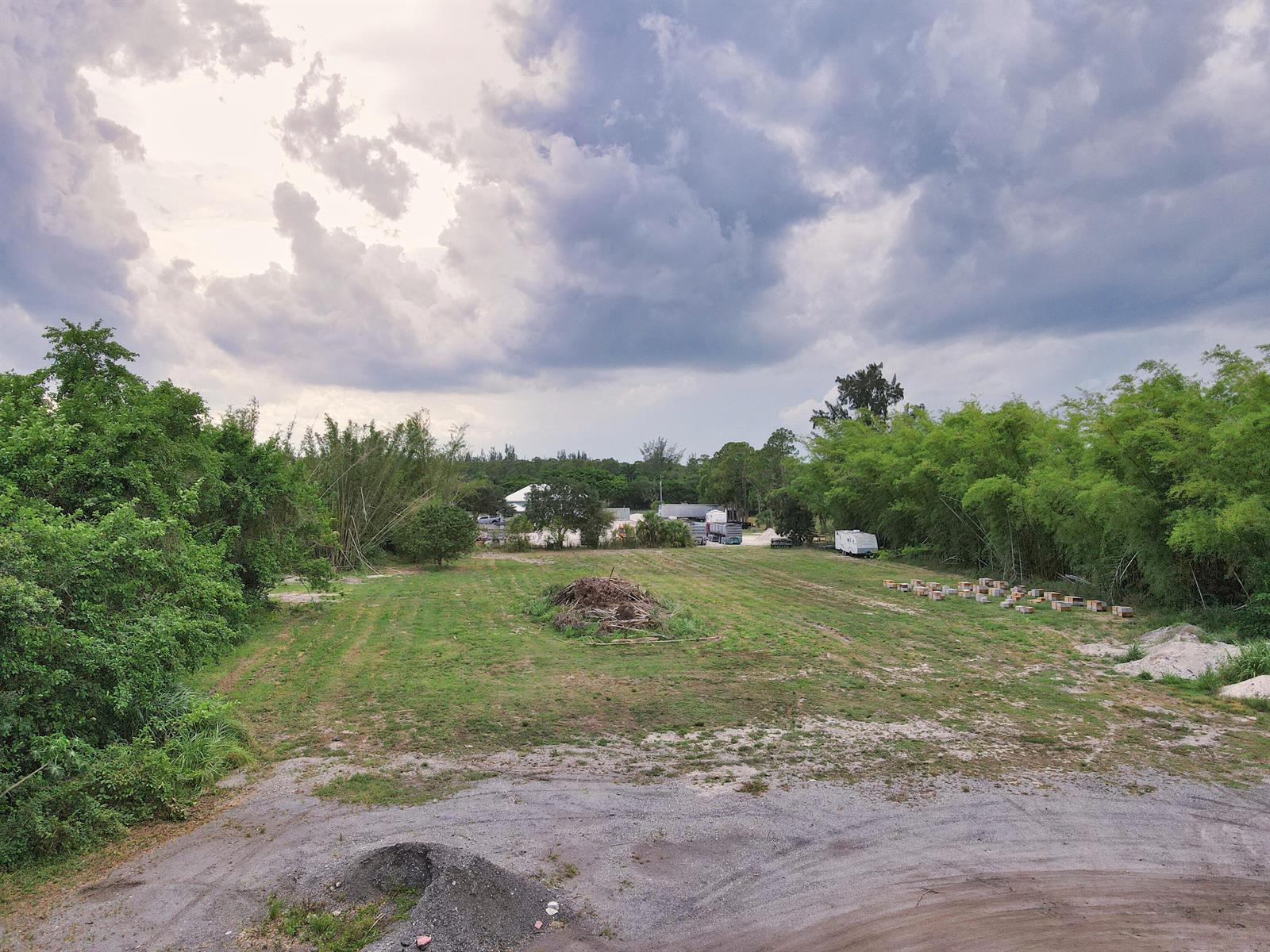 An aerial view of a grassy lot with trees, a brush pile, and beehive boxes — 2105 Jewel Lane, FL 33470, FL