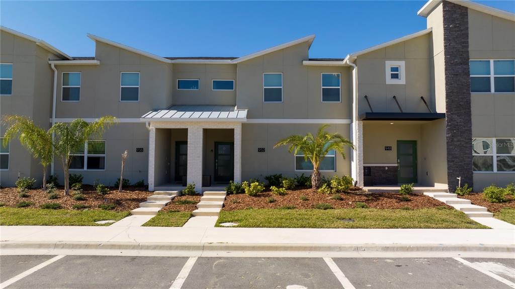A row of modern townhouses features tan siding, flat roofs, and small front entryways — 952 LEADER STREET, DAVENPORT, FL
