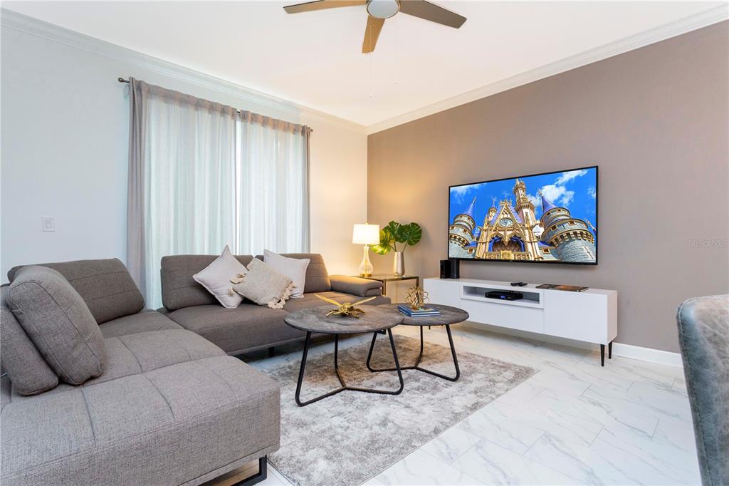 A living room features a gray sectional sofa, two round coffee tables, and a wall-mounted television — 952 LEADER STREET, DAVENPORT, FL