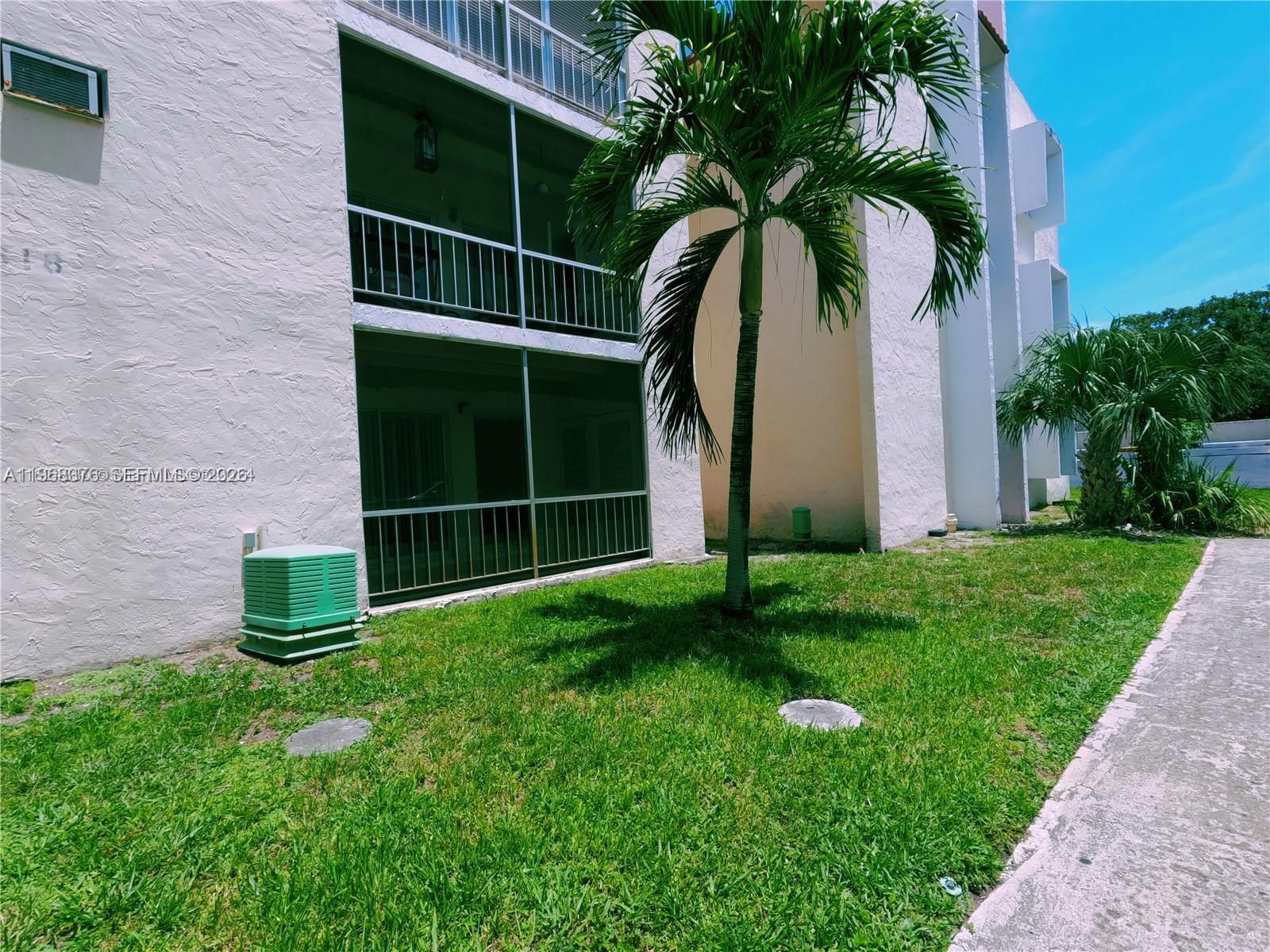 An exterior view shows a multi-story building with screened balconies, a palm tree, and grass — 618 NW 13th St # 0140, Boca Raton FL 33486, BOCA RATON, FL