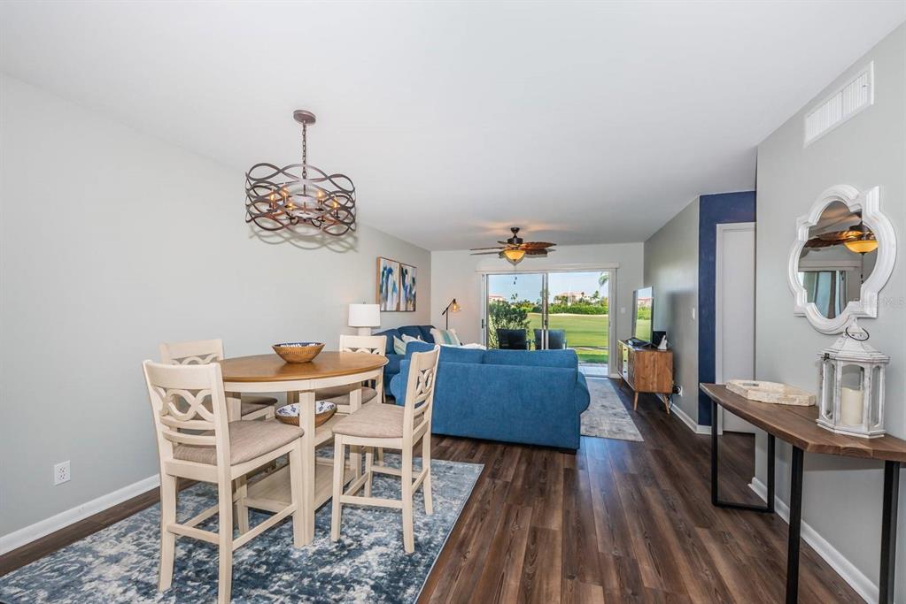 A dining area with a round table and chairs opens into a living room — 6151 BAHIA DEL MAR BOULEVARD UNIT 120, ST PETERSBURG, FL