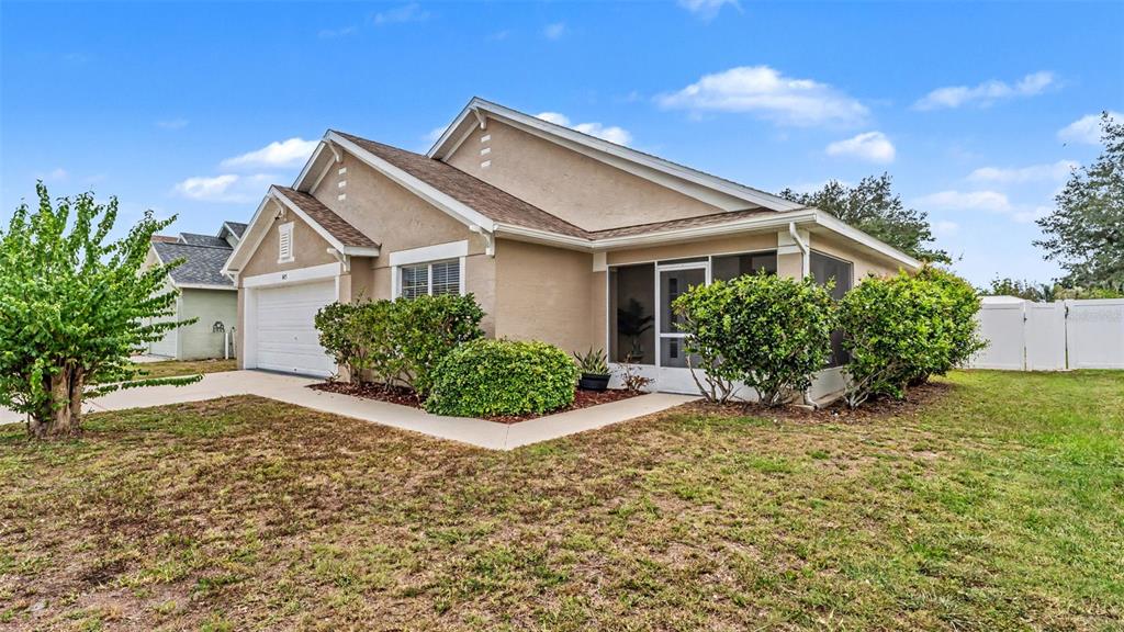 A tan, single-story house with a two-car garage and a screened-in back porch — 8435 ADELE ROAD, LAKELAND, FL