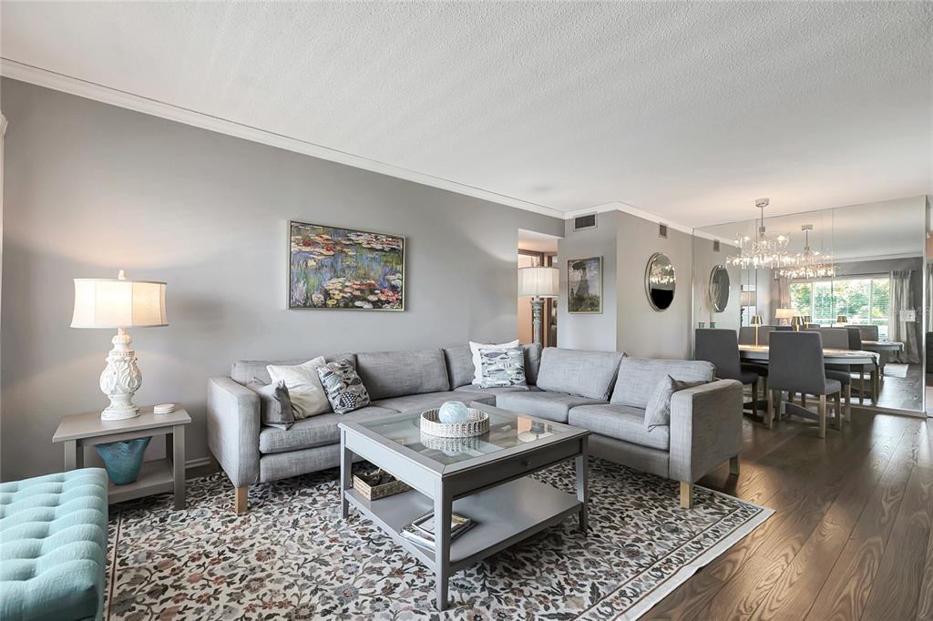 A living room with a grey sectional sofa, coffee table, area rug, and dining area — 2461 RHODESIAN DRIVE UNIT 73, CLEARWATER, FL