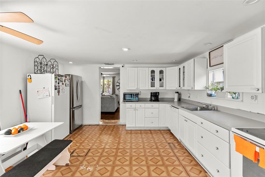 A kitchen with white cabinets, stainless steel appliances, and patterned tile flooring — 3334 AVENUE J NW, WINTER HAVEN, FL