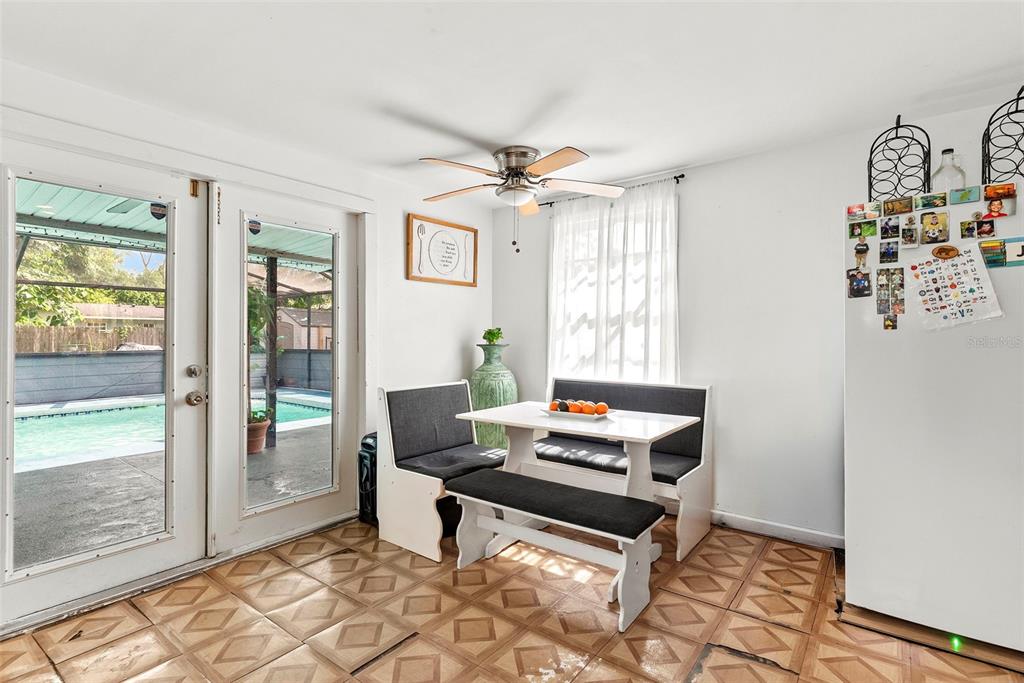 A breakfast nook features a dining set, tiled floors, and glass doors overlooking a pool — 3334 AVENUE J NW, WINTER HAVEN, FL