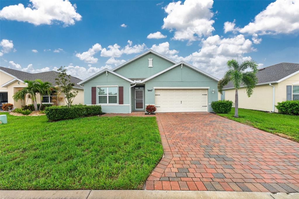 A single-story house with a light green exterior, brick paver driveway, and a two-car garage — 4107 MANATEE LANE, PORT CHARLOTTE, FL