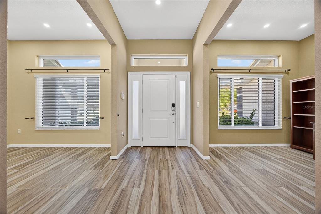 An entryway features a white front door, light-colored walls, and wood-look flooring — 25900 AYSEN DRIVE, PUNTA GORDA, FL