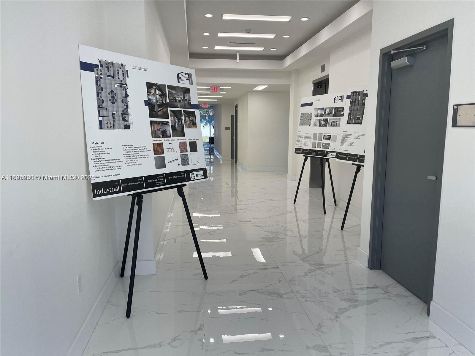 A hallway features white marble flooring and two display boards on easels showing design plans — 10450 NW 33rd St # 102, Doral FL 33172, DORAL, FL