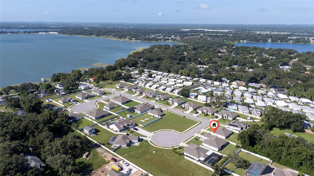 An aerial view shows a suburban neighborhood with houses near a large lake — 252 SAMANTHA AVE,, AUBURNDALE, FL