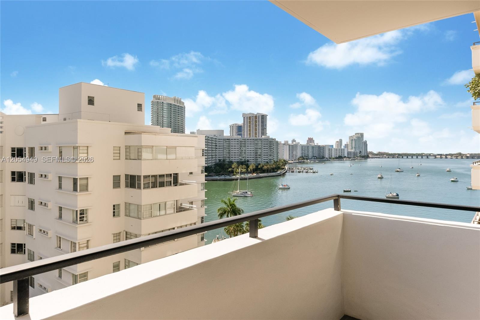 A balcony overlooks a bay with several boats and a distant city skyline — 11 Island Ave # 908, Miami Beach FL 33139, MIAMI BEACH, FL